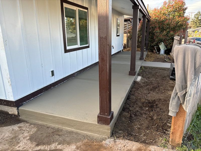 A white house with a porch and a concrete walkway.