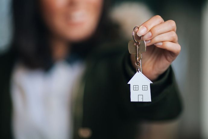 Lady holding key with house keychain