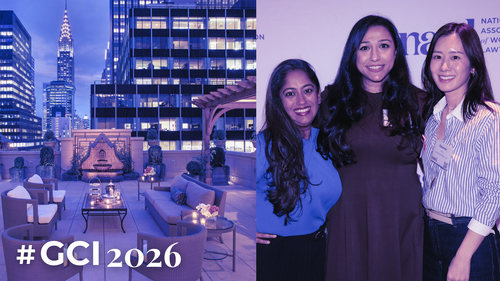 A city building rooftop at night, and three people smiling in front of a branded backdrop.