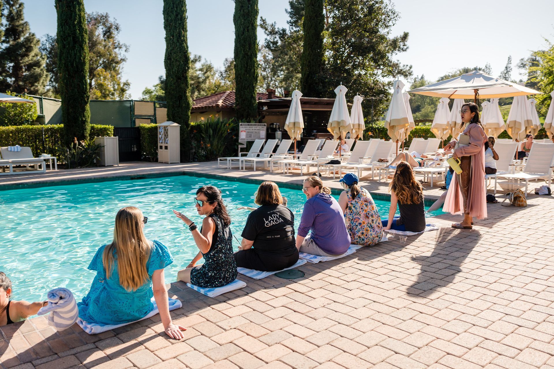 (un)conference participants chat and sit around a pool.