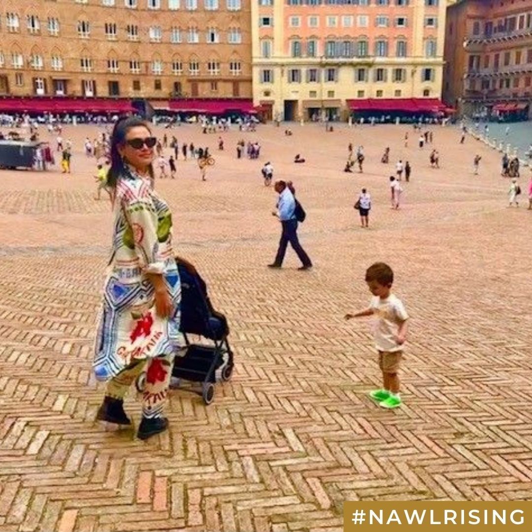 A woman with a stroller and child at a busy plaza.