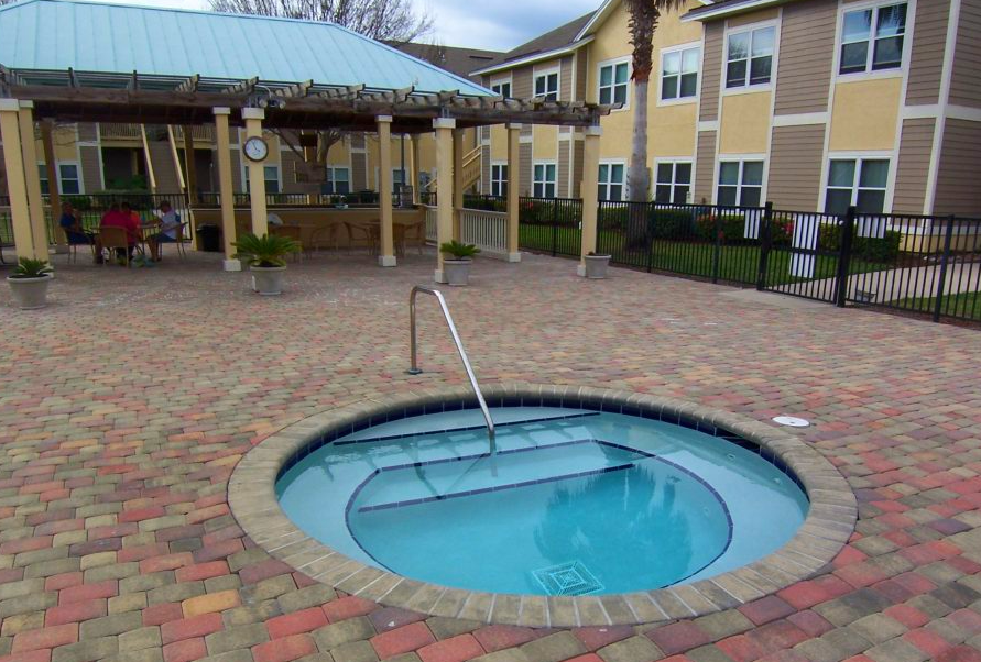 a hot tub is surrounded by bricks in front of a building