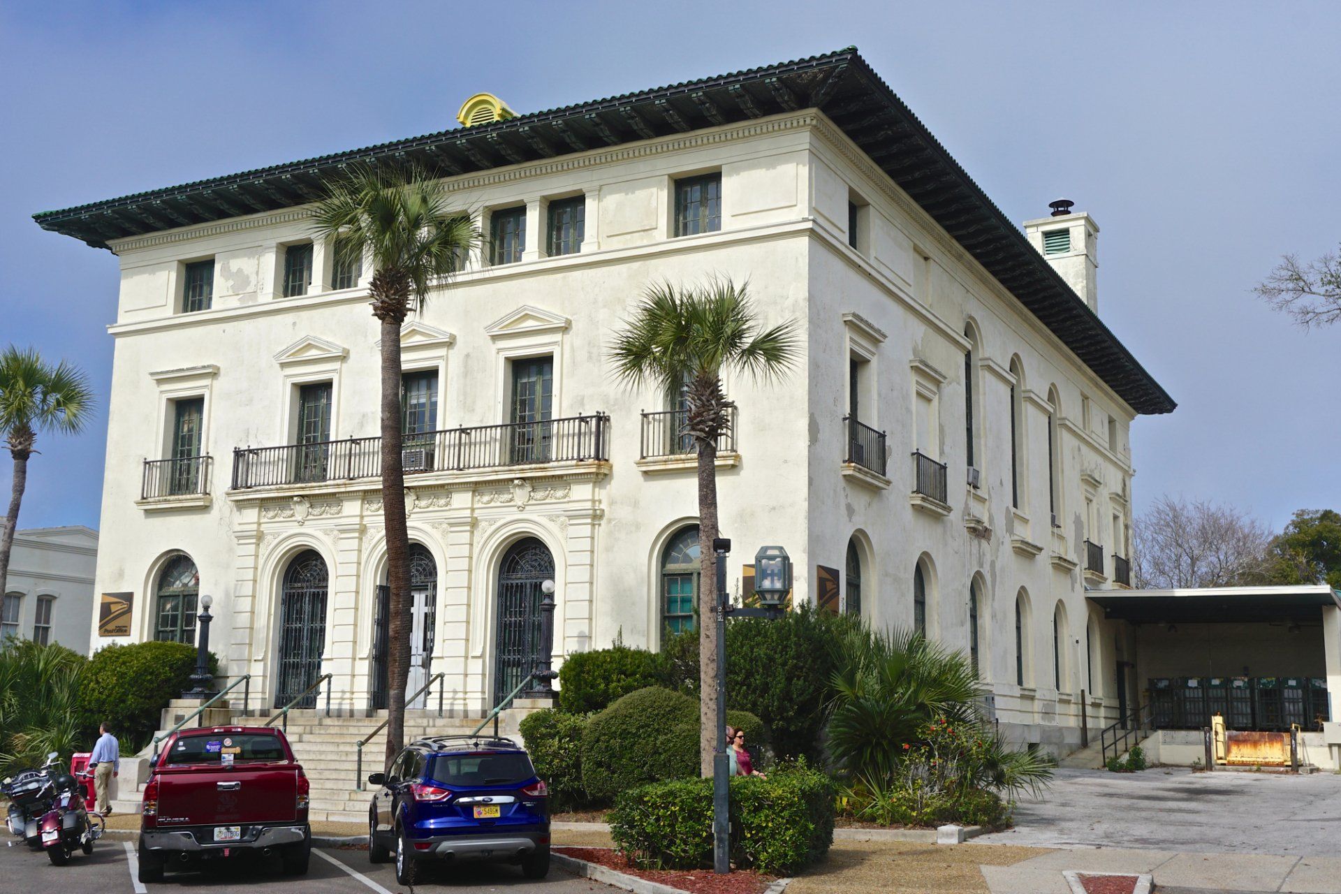a large white building with cars parked in front of it