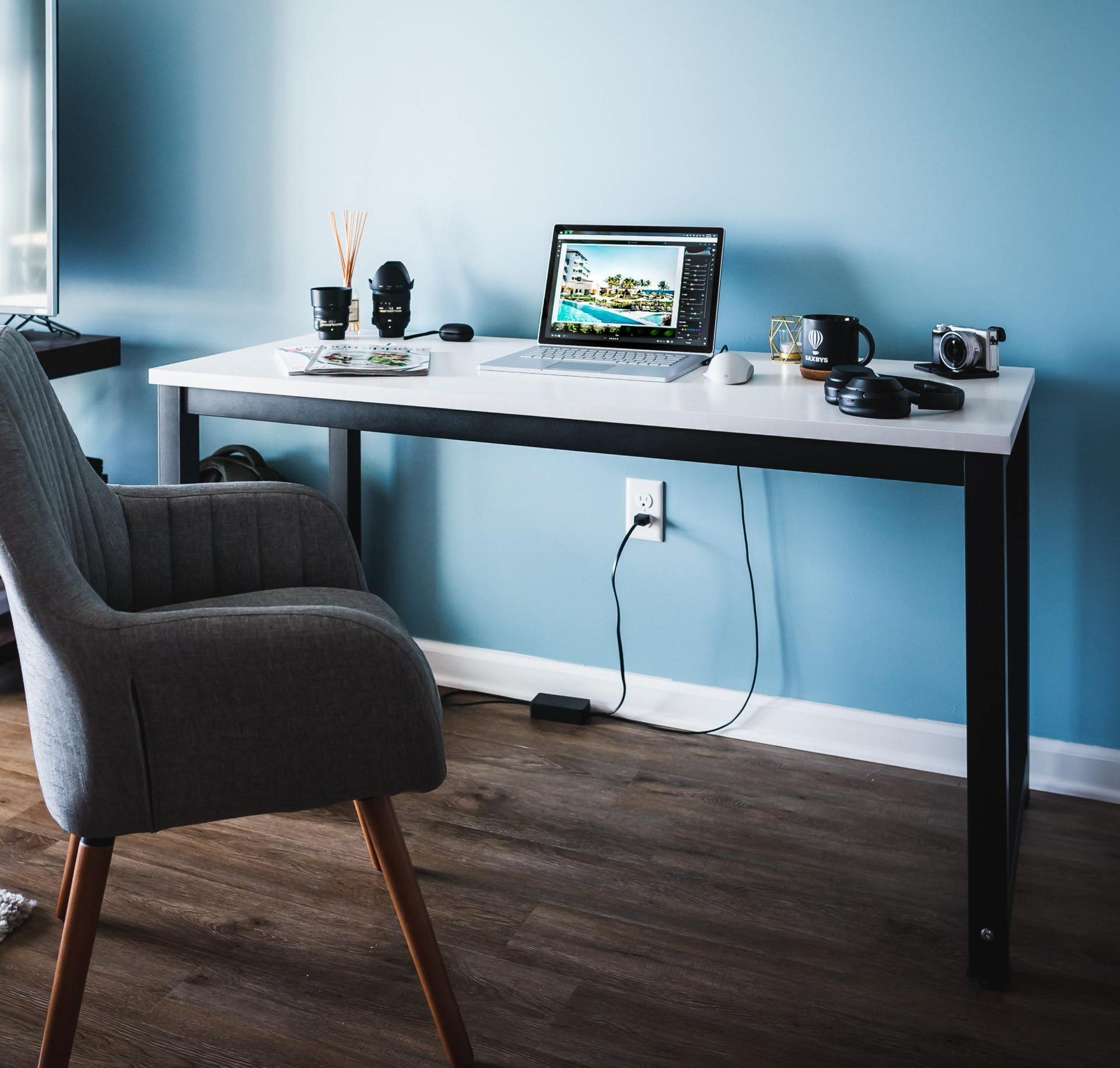 a chair sits in front of a desk with a laptop on it