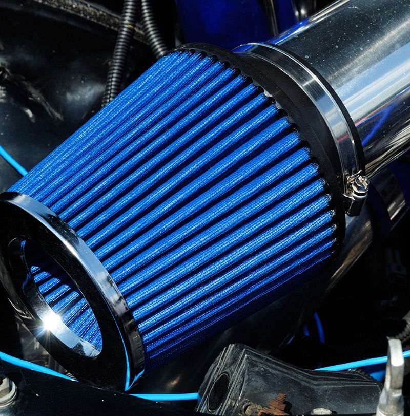 A close up of a blue air filter in a car