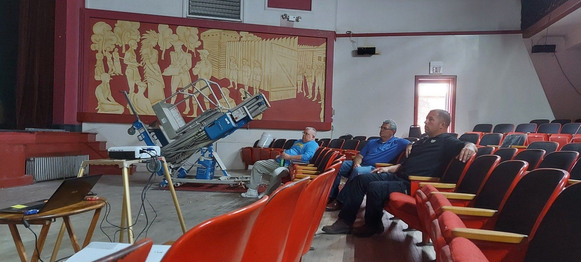 A group of people are sitting in an auditorium watching a presentation