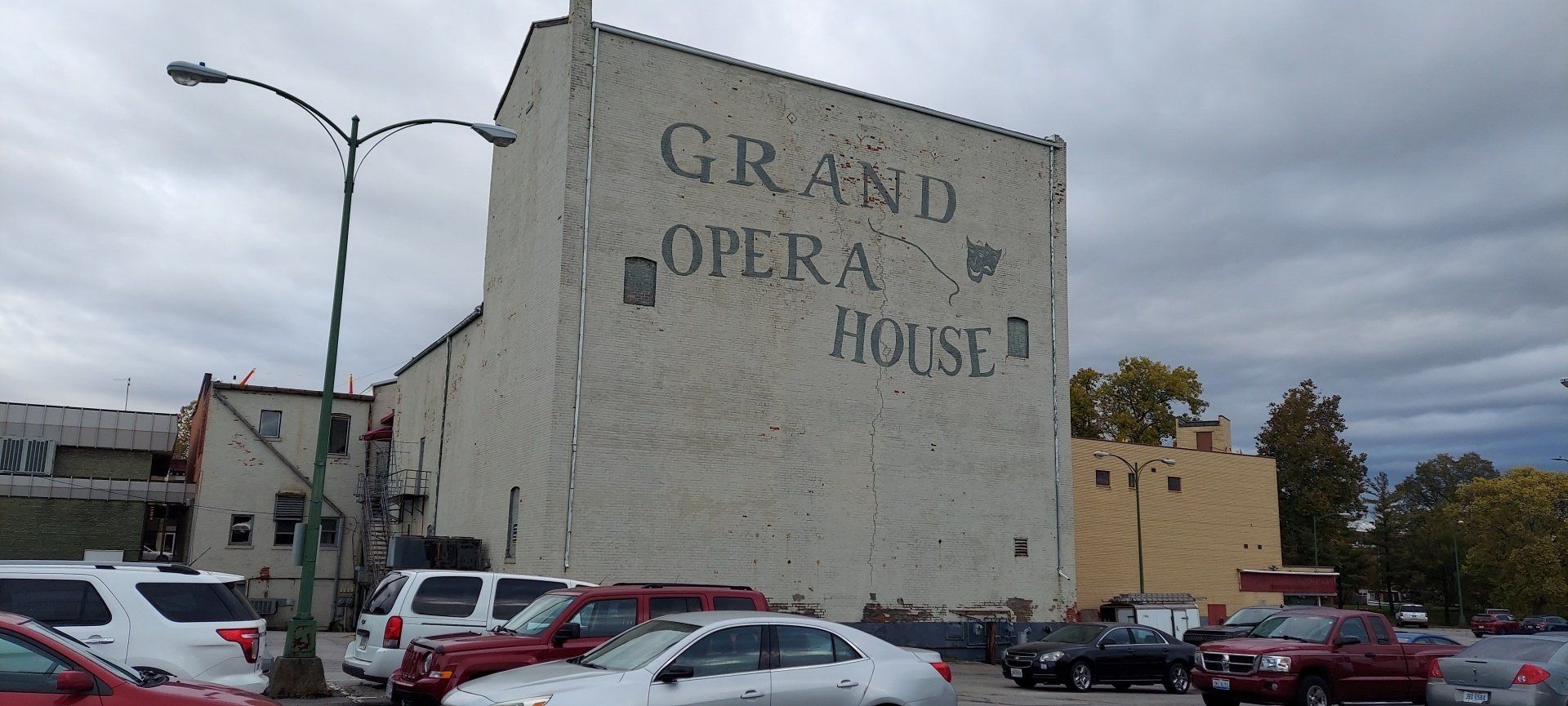 A white building with the words grand opera house painted on it