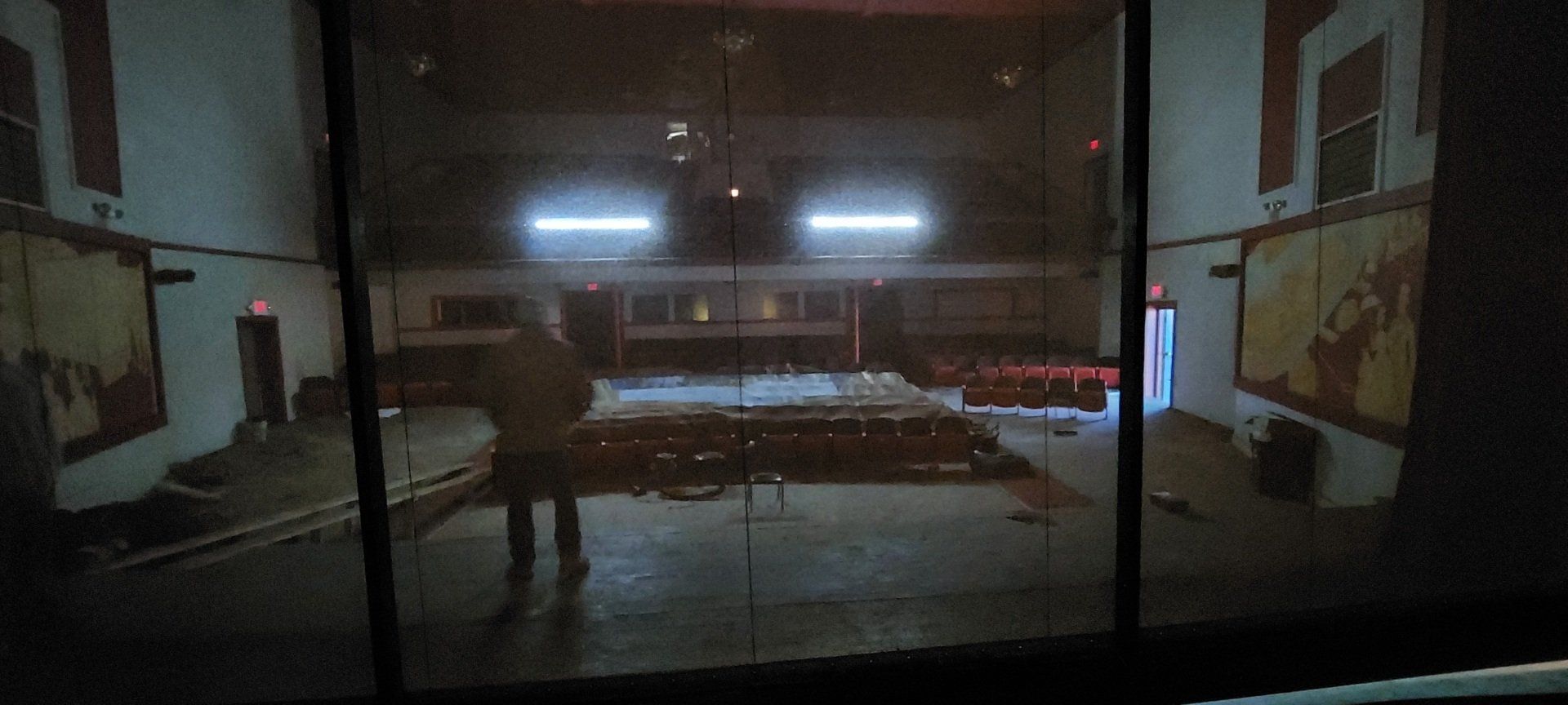 A man is standing on a stage in a dark room.
