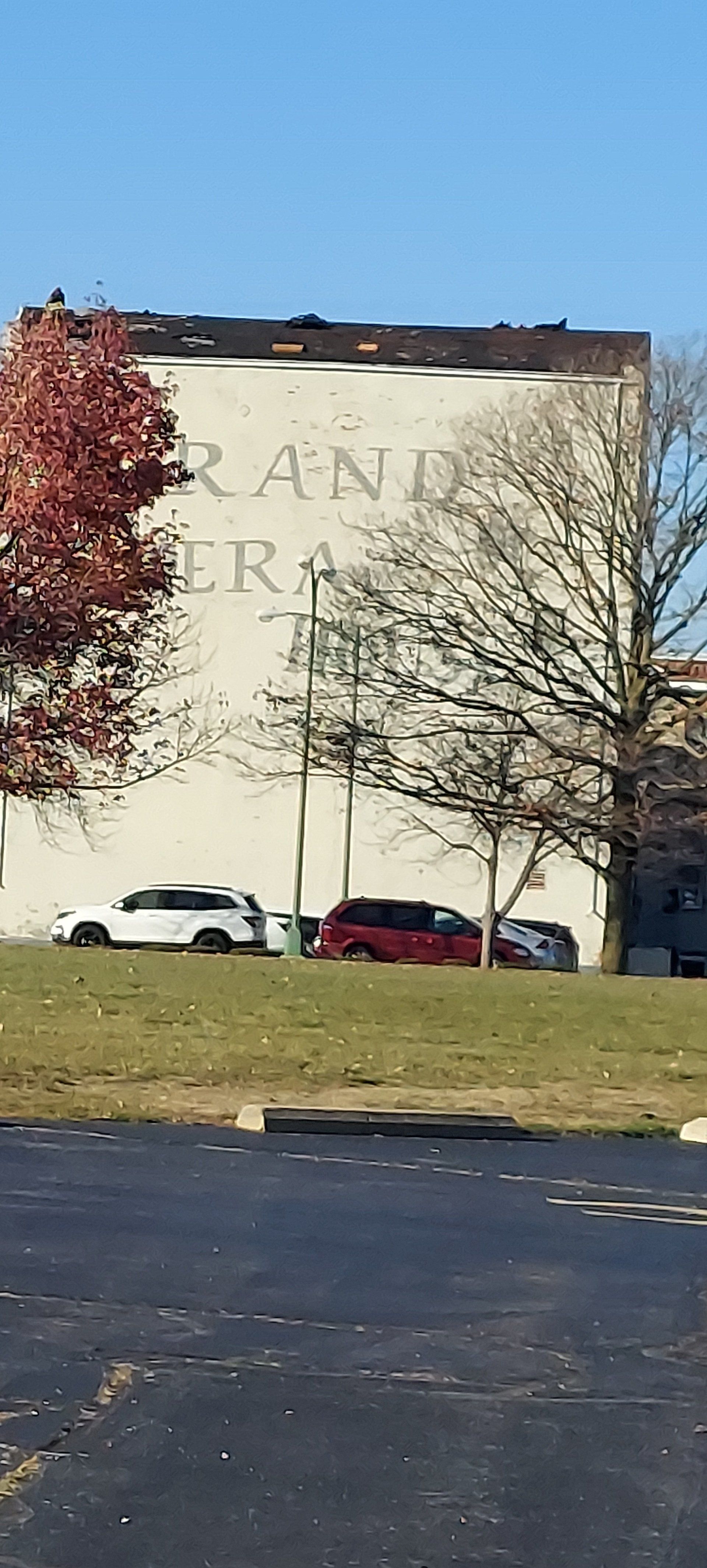 A large white building with a lot of cars parked in front of it.