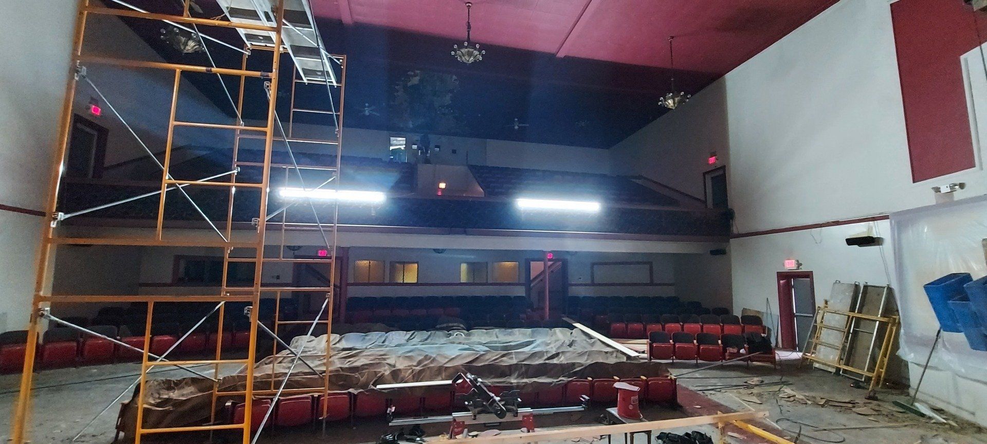 An empty auditorium with a red ceiling and scaffolding.