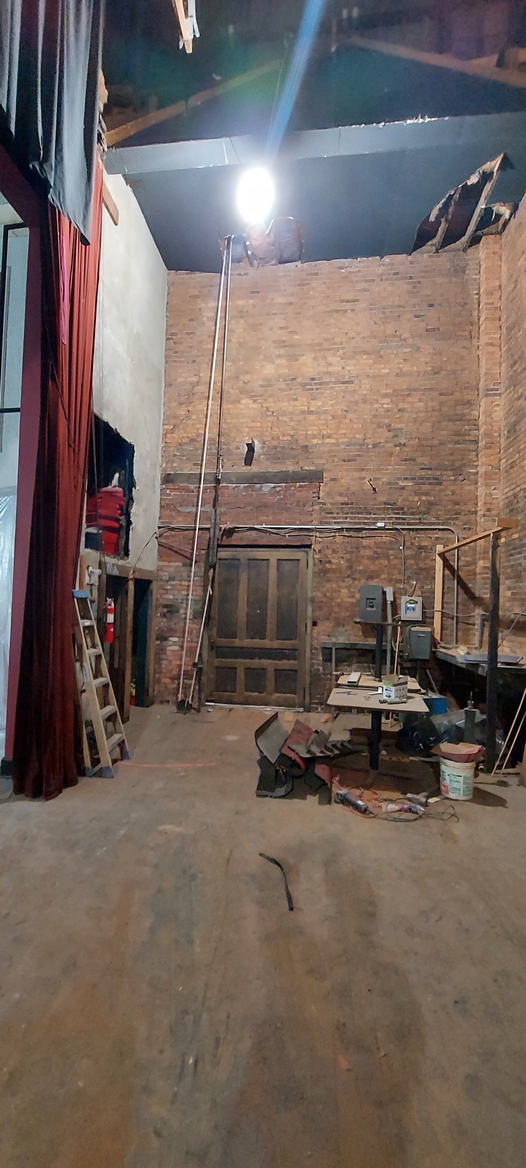A large empty warehouse with a ladder in the middle of it.