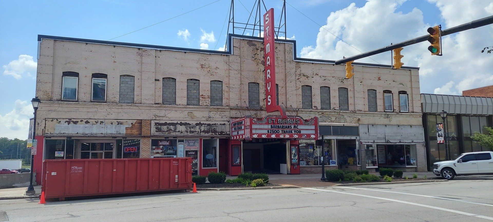 A large building with a lot of windows is sitting on the corner of a street.