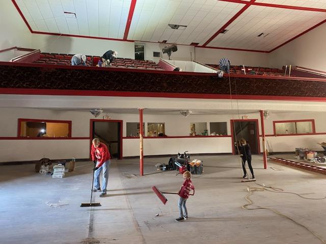A group of people are cleaning the floor of a building