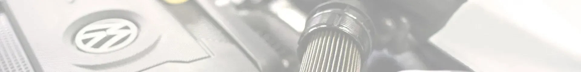 Imagem em close-up do motor de um veículo com o logotipo da VW visível. 