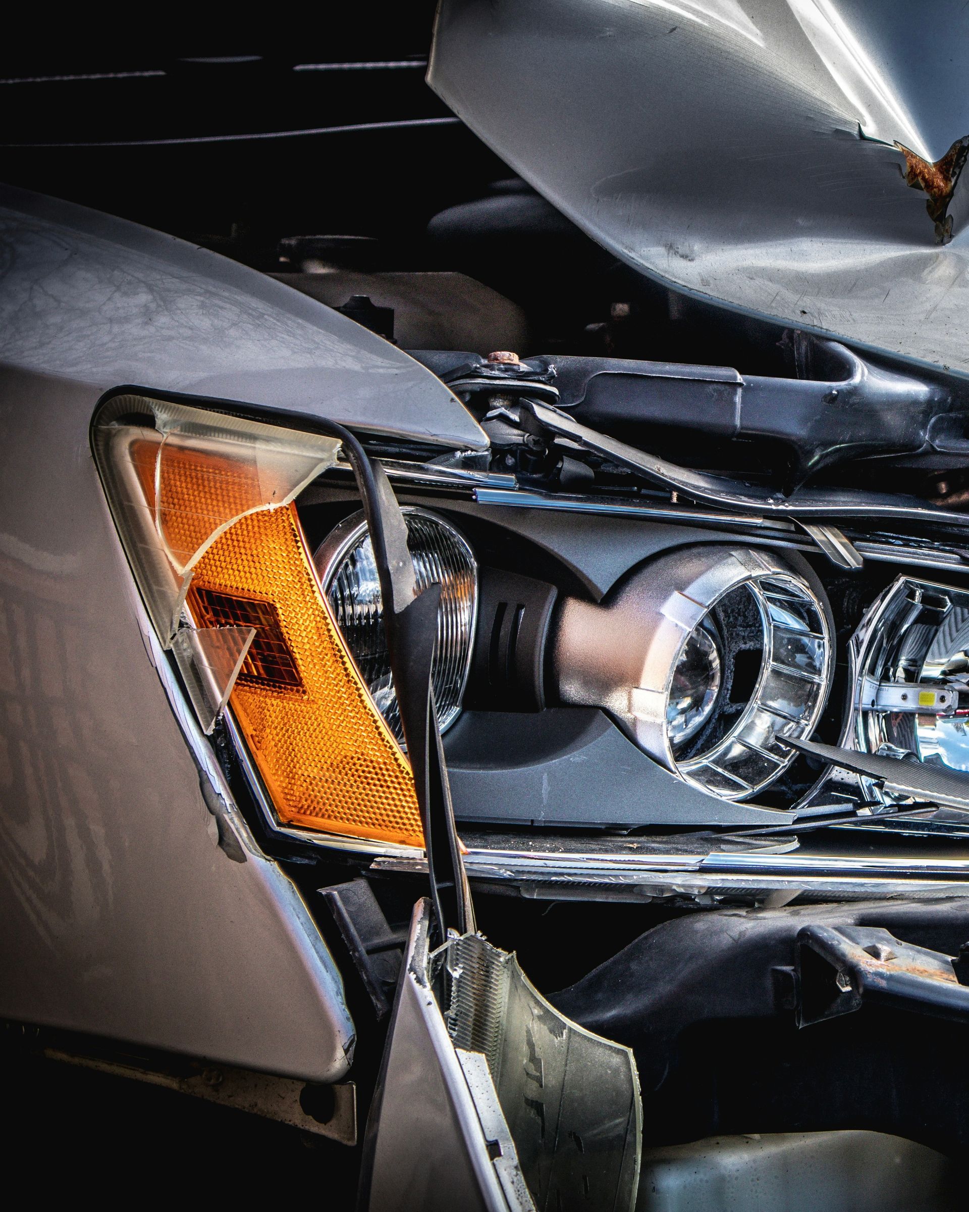 A close up of a damaged car with the hood open
