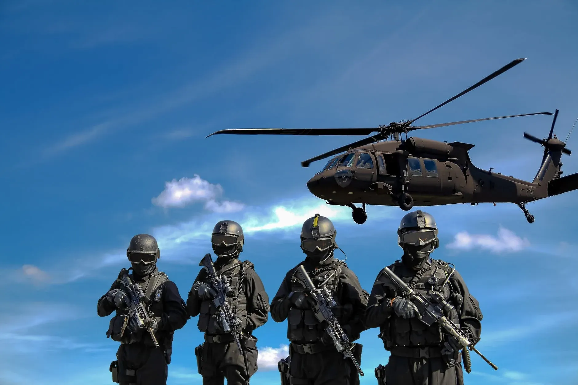four-soldiers-carrying-rifles-near-helicopter-under-blue-sky