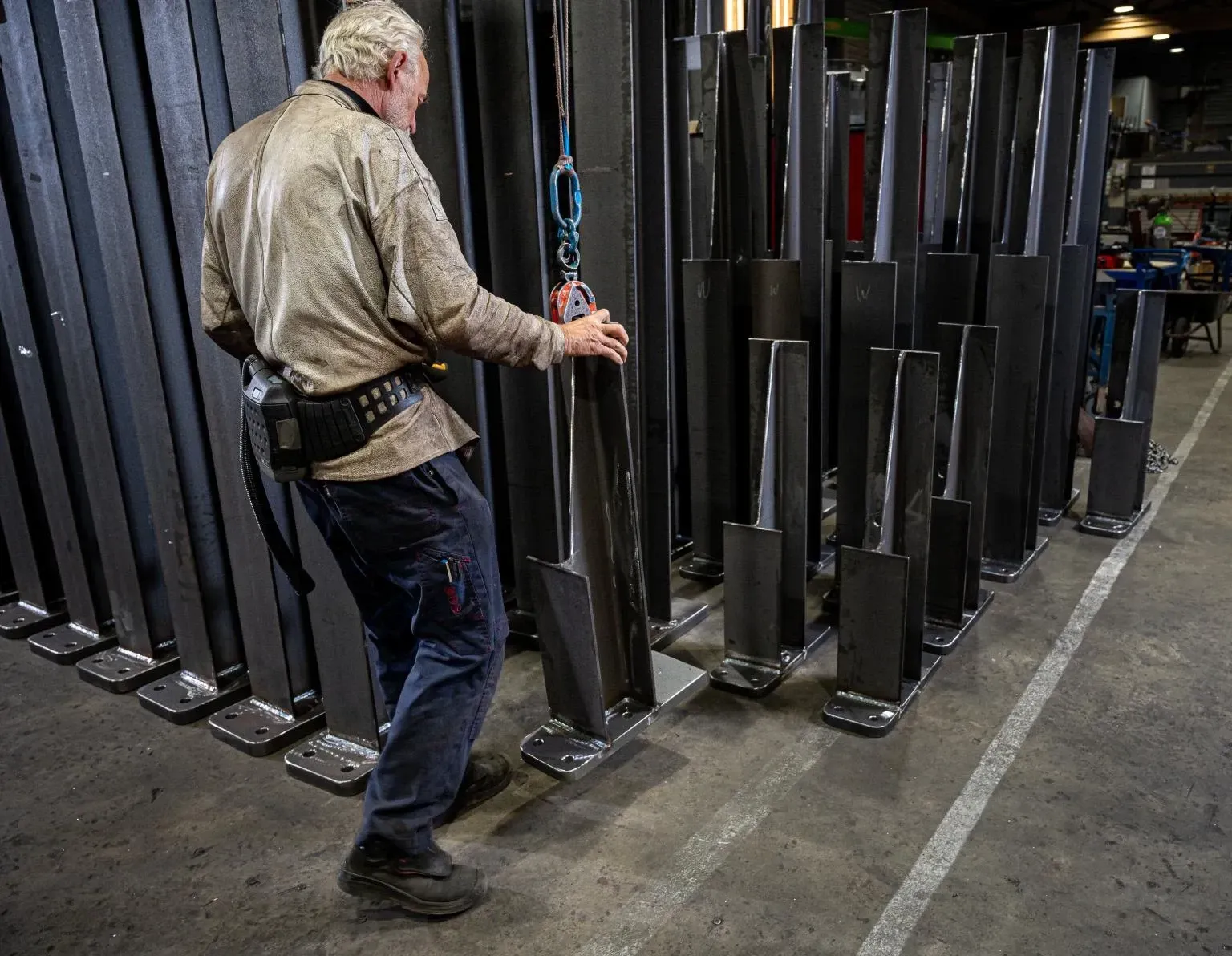 Een man staat voor een rij metalen palen. Willems Boven-Leeuwen