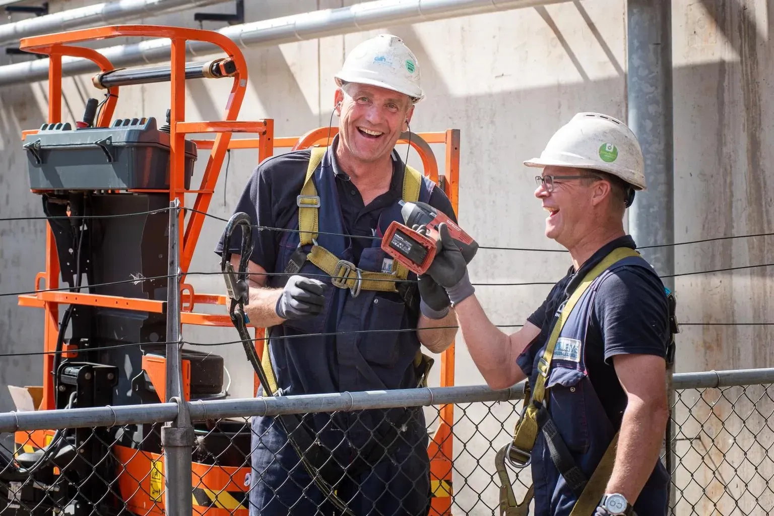 Twee bouwvakkers staan ​​naast elkaar en lachenDoor Willems Boven-Leeuwen.