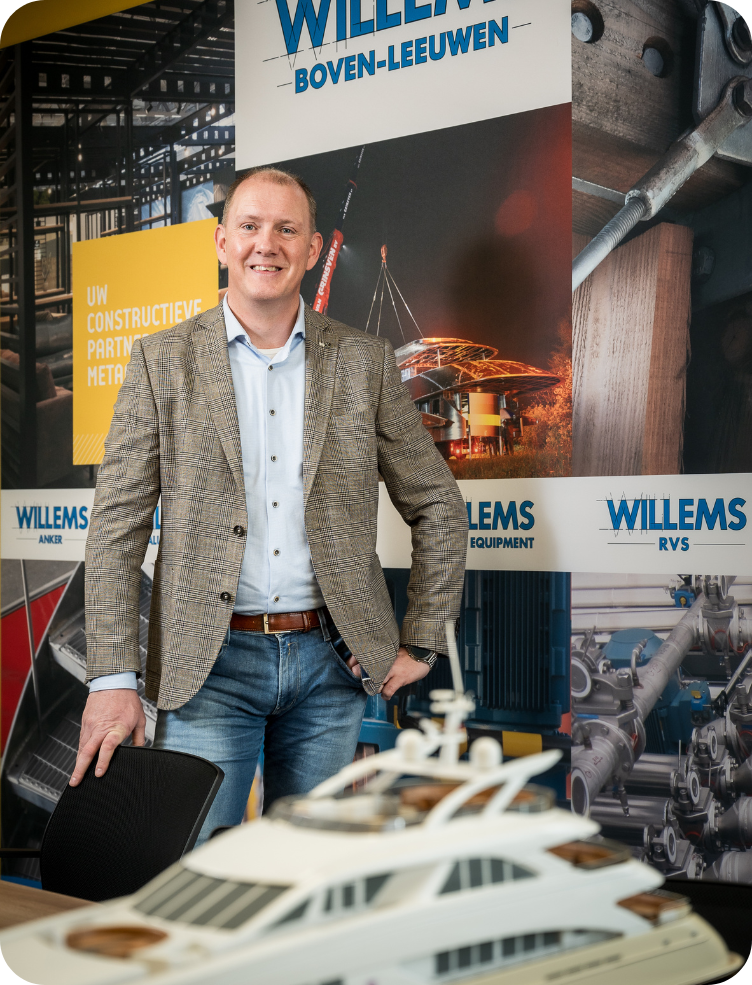 Een man in pak staat voor een bord met de tekst willems. Jurgen van Dinteren.