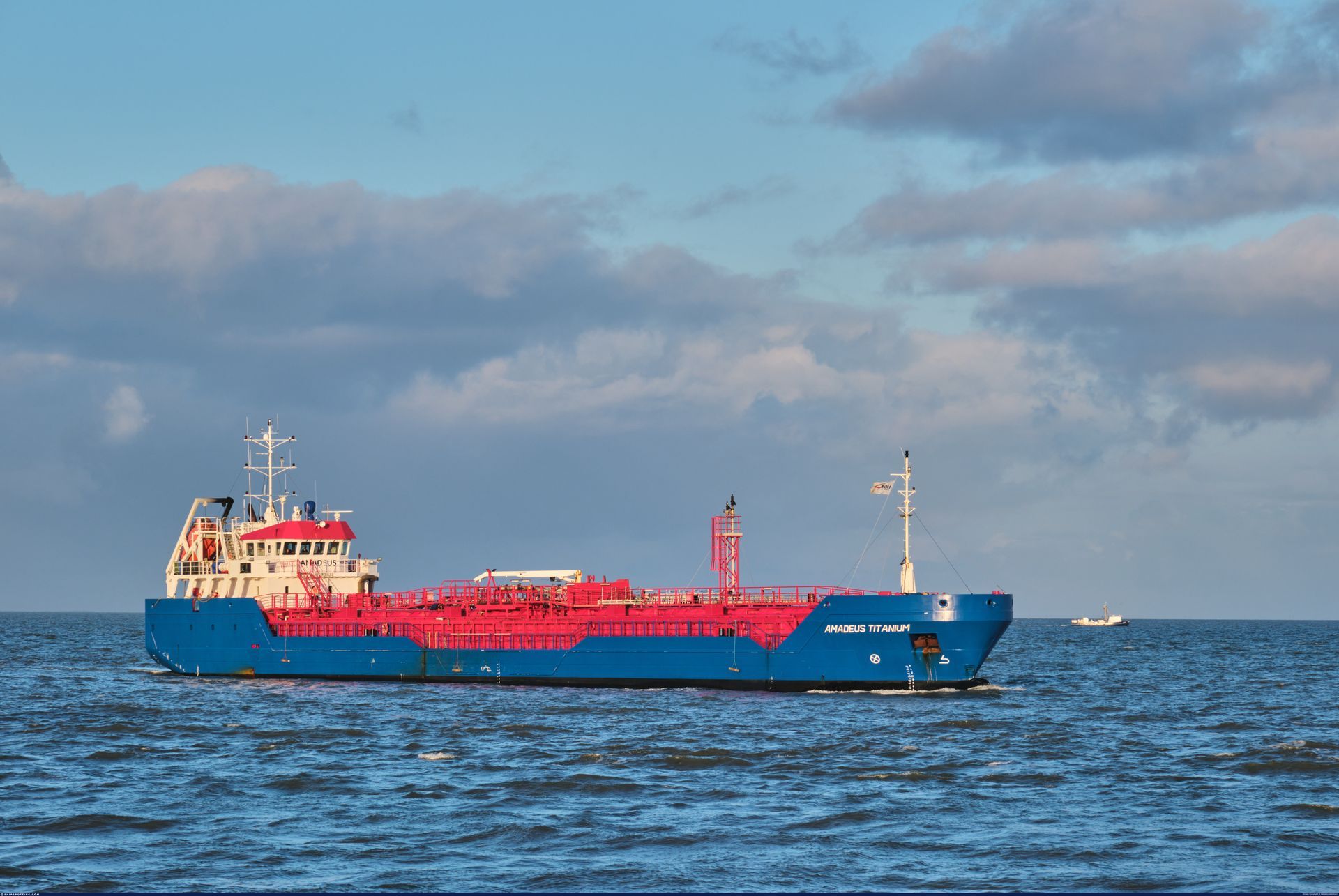 Een groot blauw en rood tankschip drijft op een grote watermassa.