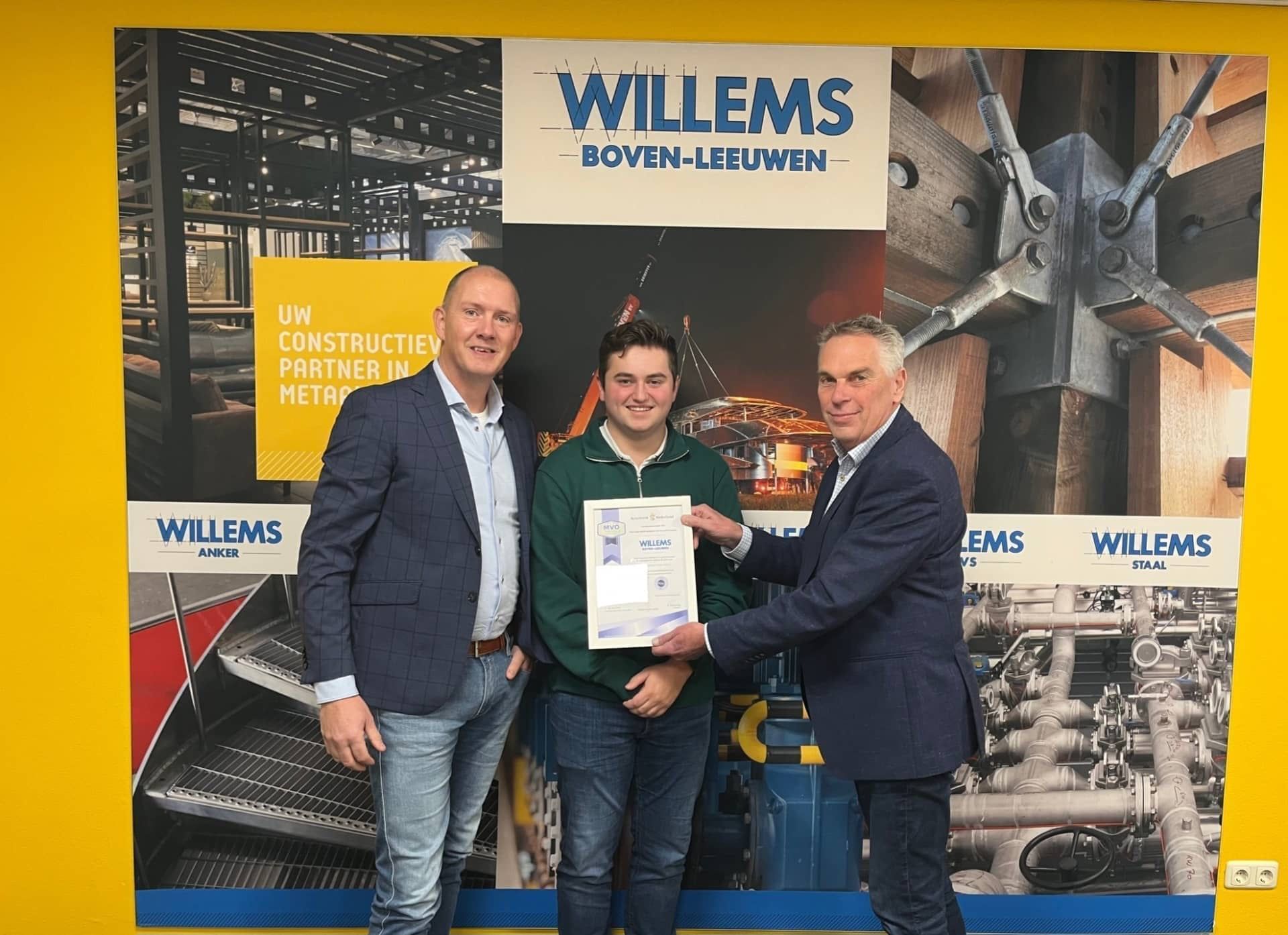 Drie mannen staan naast elkaar voor een muur met de tekst willems. Willems Boven-Leeuwen