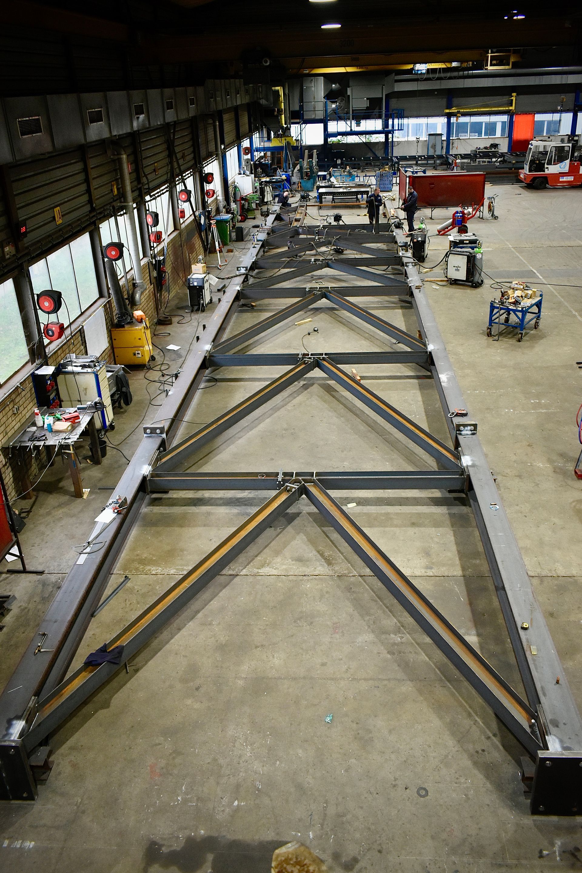 In een fabriek wordt een grote metalen constructie gebouwd