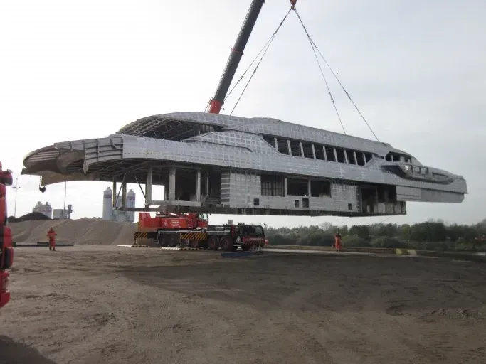 Een gebouw met een gebogen dak en een blauwe lucht op de achtergrond Door Willems Boven-Leeuwen.