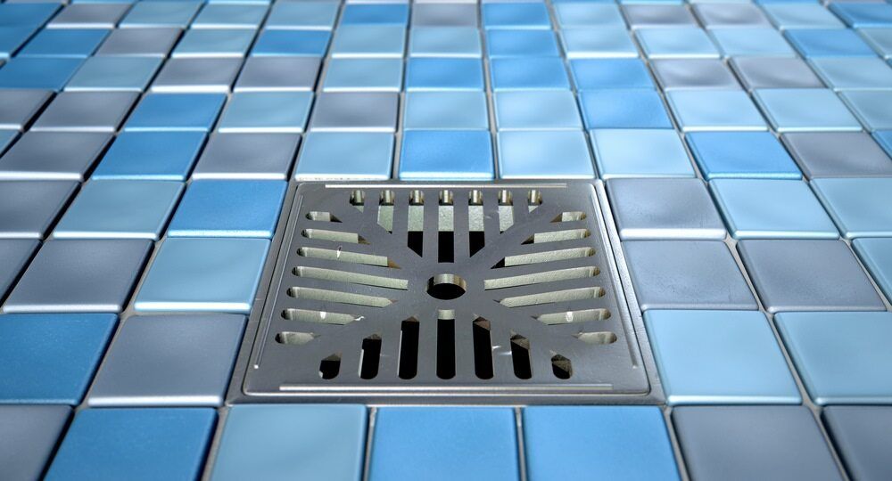 A Drain On A Tiled Floor In A Bathroom — Gordo's Plumbing Service In Wagga Wagga, NSW