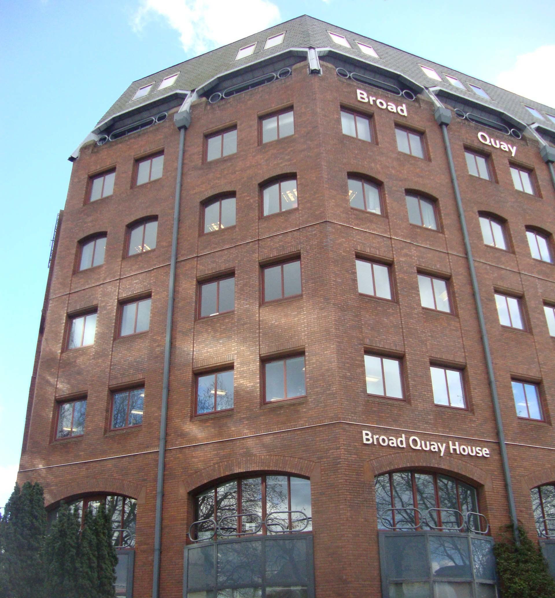 Brick building, Broad Quay House, with arched windows on the ground floor and multiple windows above.