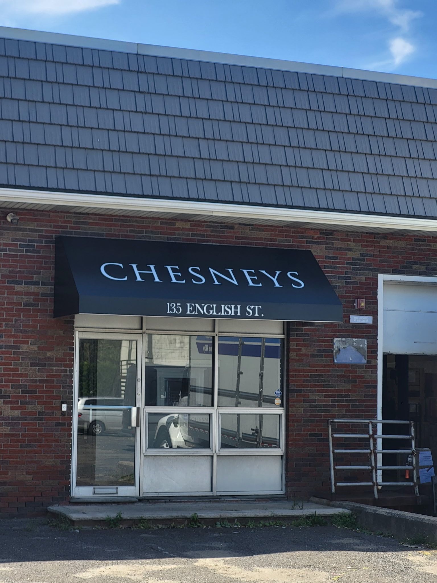 Chesneys storefront with black awning and brick exterior.  