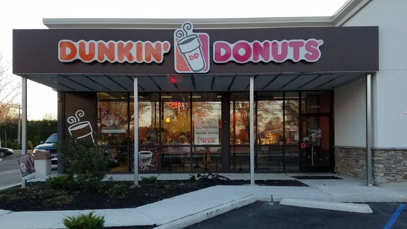 Dunkin' Donuts storefront with orange and brown logo above glass windows.