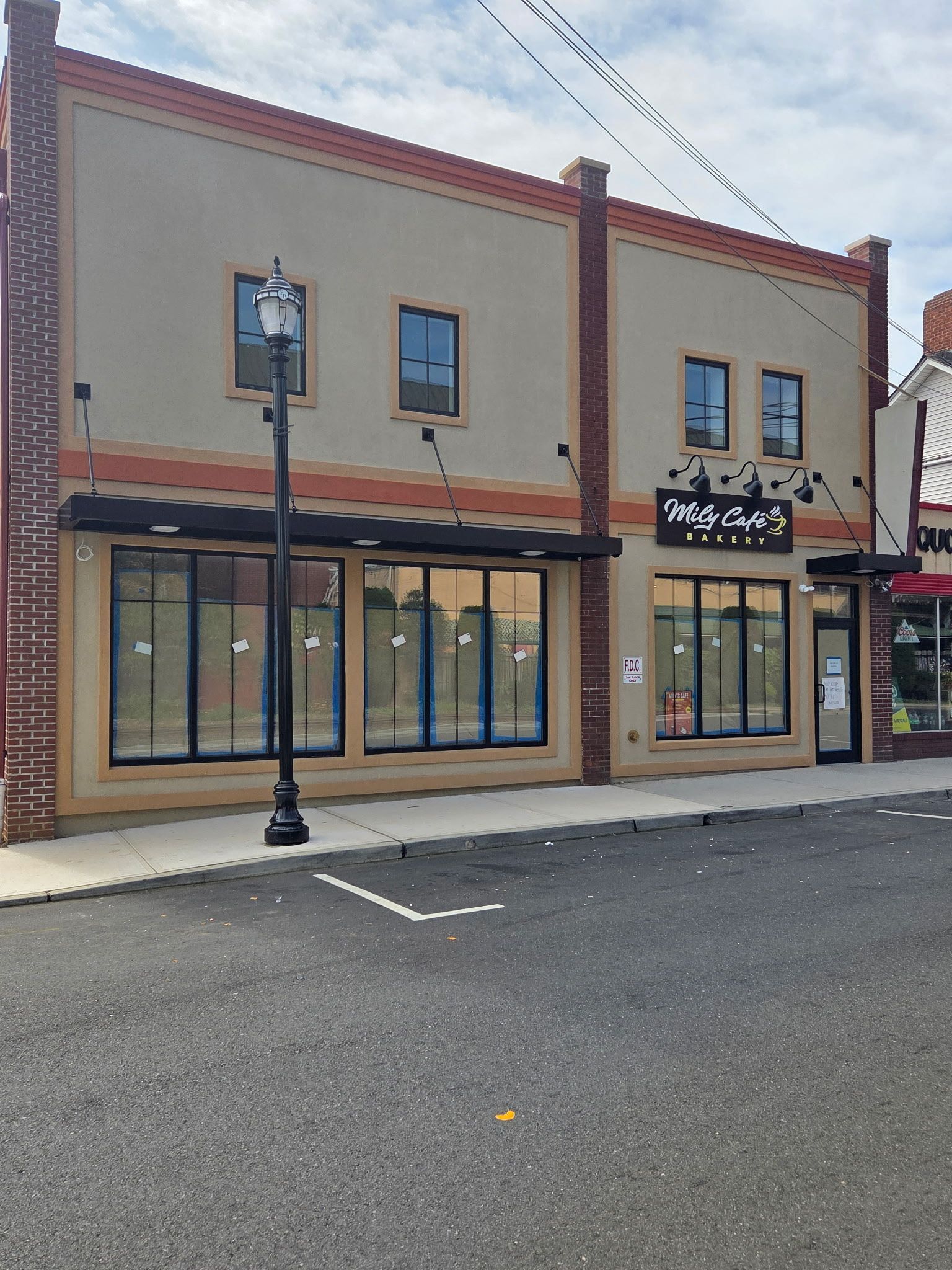 A two-story building with storefront windows and black awnings. 