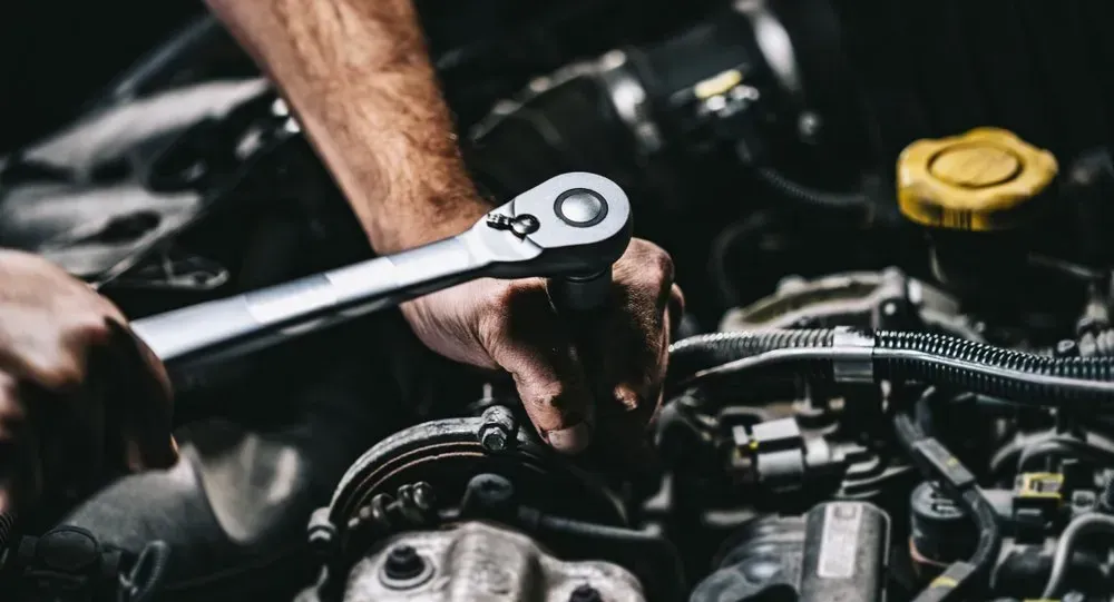 Mechanic's Hands Using a Wrench on a Car Engine — B Wild Auto Repairs In North Gosford, NSW