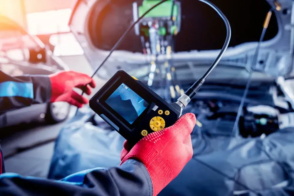 Hands in Red Gloves Holding an Inspection Camera — B Wild Auto Repairs In North Gosford, NSW