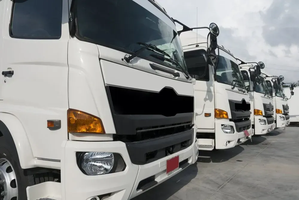Line of White Semi-trucks Parked Outdoors on a Cloudy Day — B Wild Auto Repairs In North Gosford, NSW