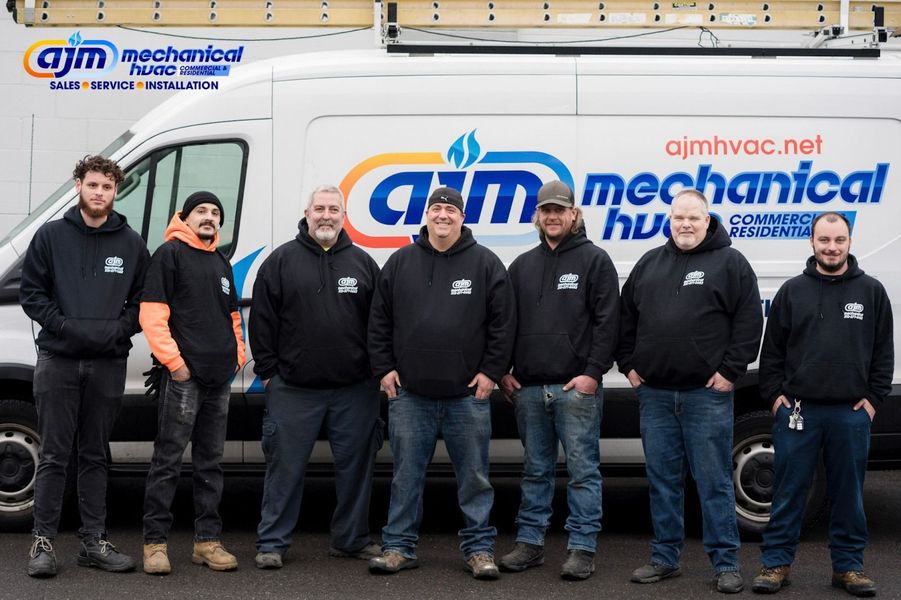 Seven men in front of a white van with the company logo 