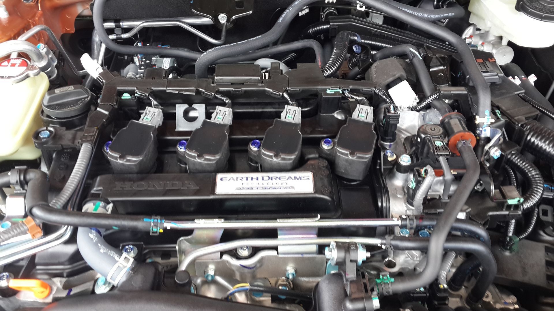 A close up of a car engine with a lot of wires coming out of it.