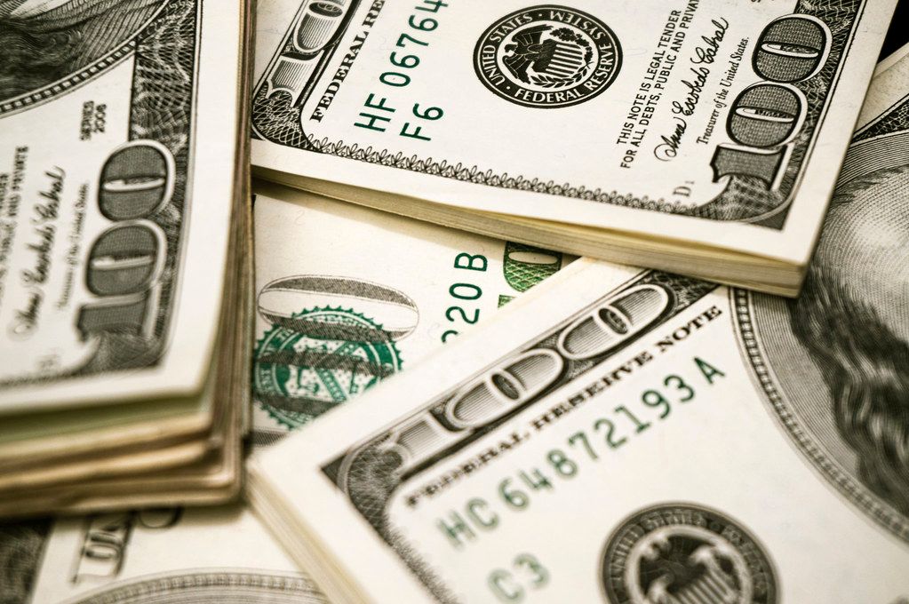 A pile of 100 dollar bills are stacked on top of each other