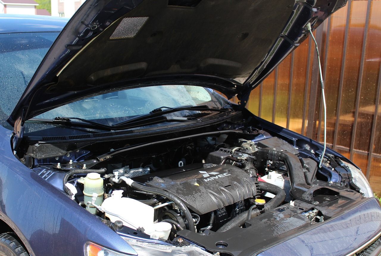 The hood of a blue car is open and the engine is visible