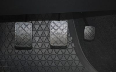 A close up of a car 's brake and clutch pedals.