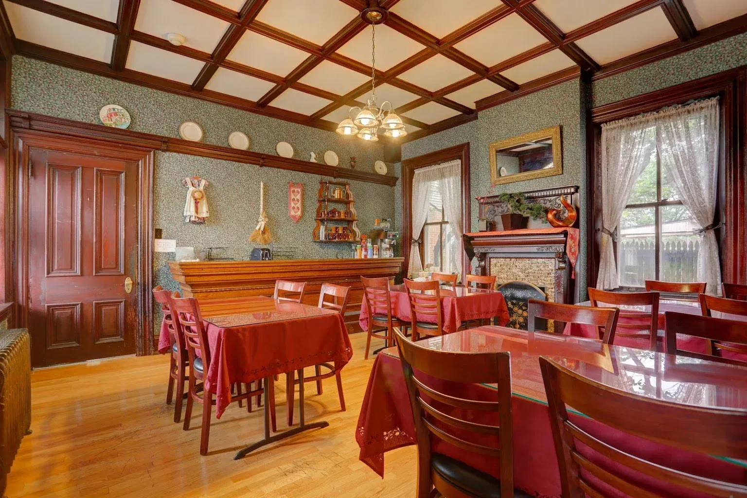 A dining room with tables and chairs and a fireplace.
