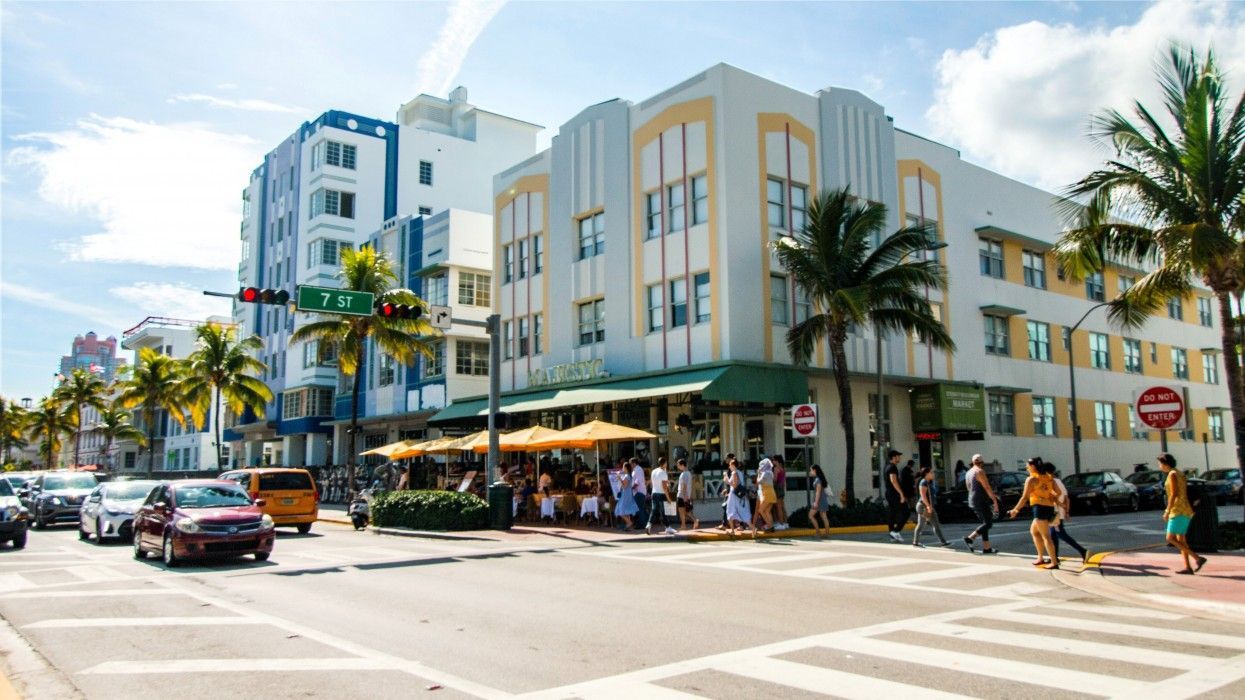 A group of people are crossing a street in front of a building.