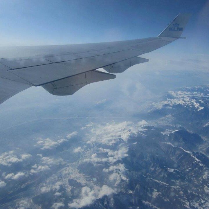 et klm fly flyver over bjerge og skyer