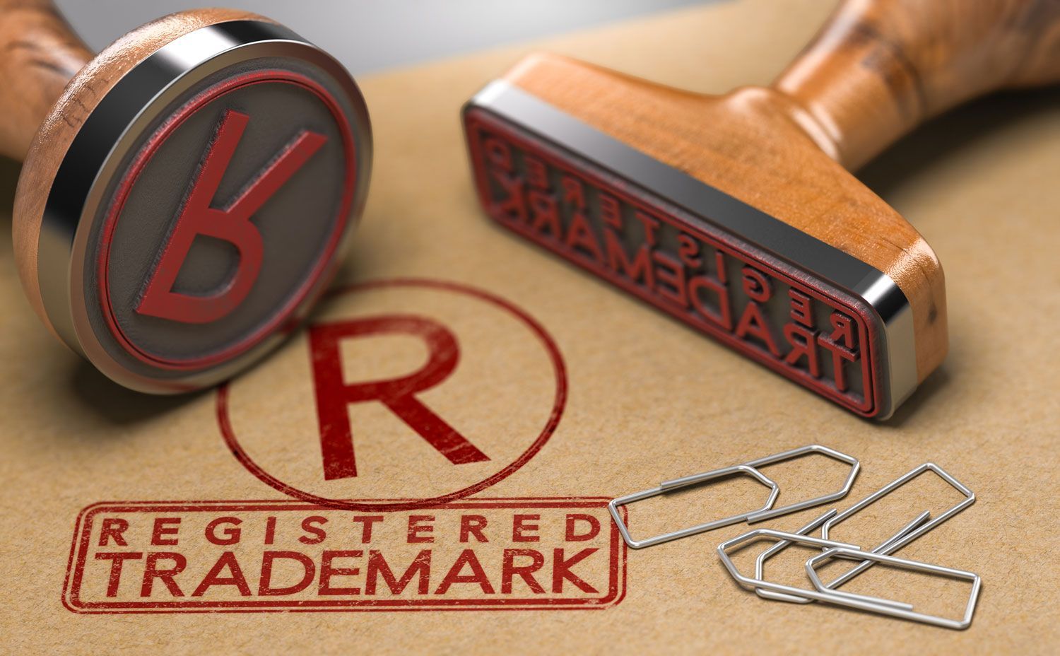 two rubber stamps with the text registered trademark and the symbol R over brown paper background