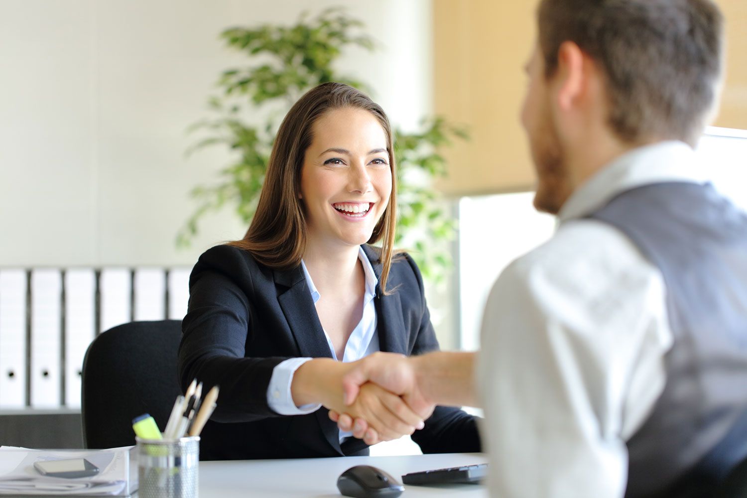 Happy business people handshaking after deal or interview at office