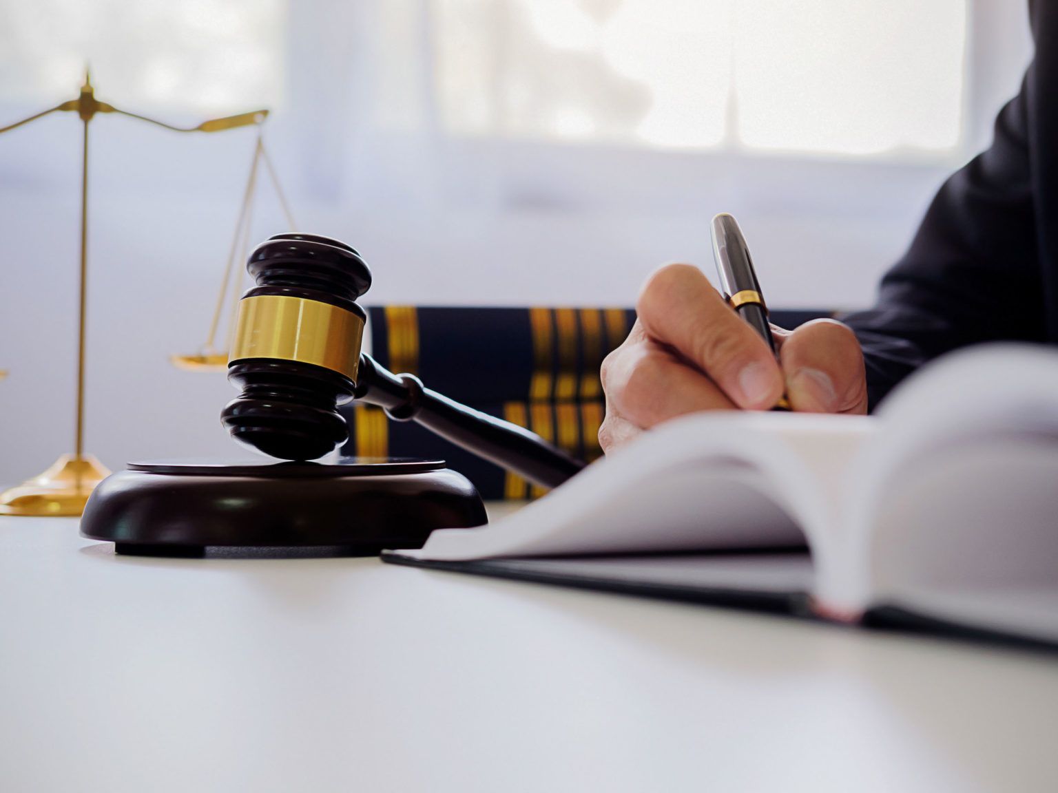 a person sitting at a table with a book and a gavel