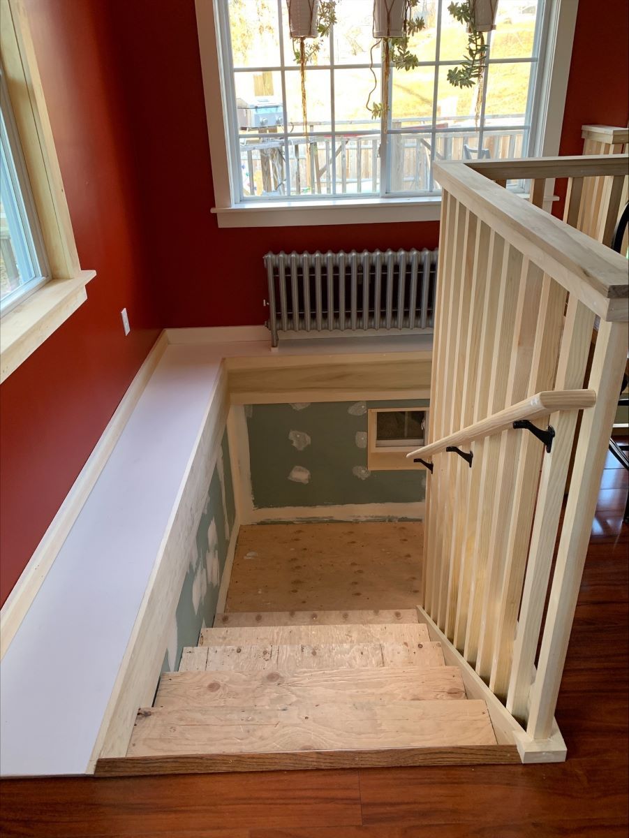 A wooden staircase with a white railing and a window.