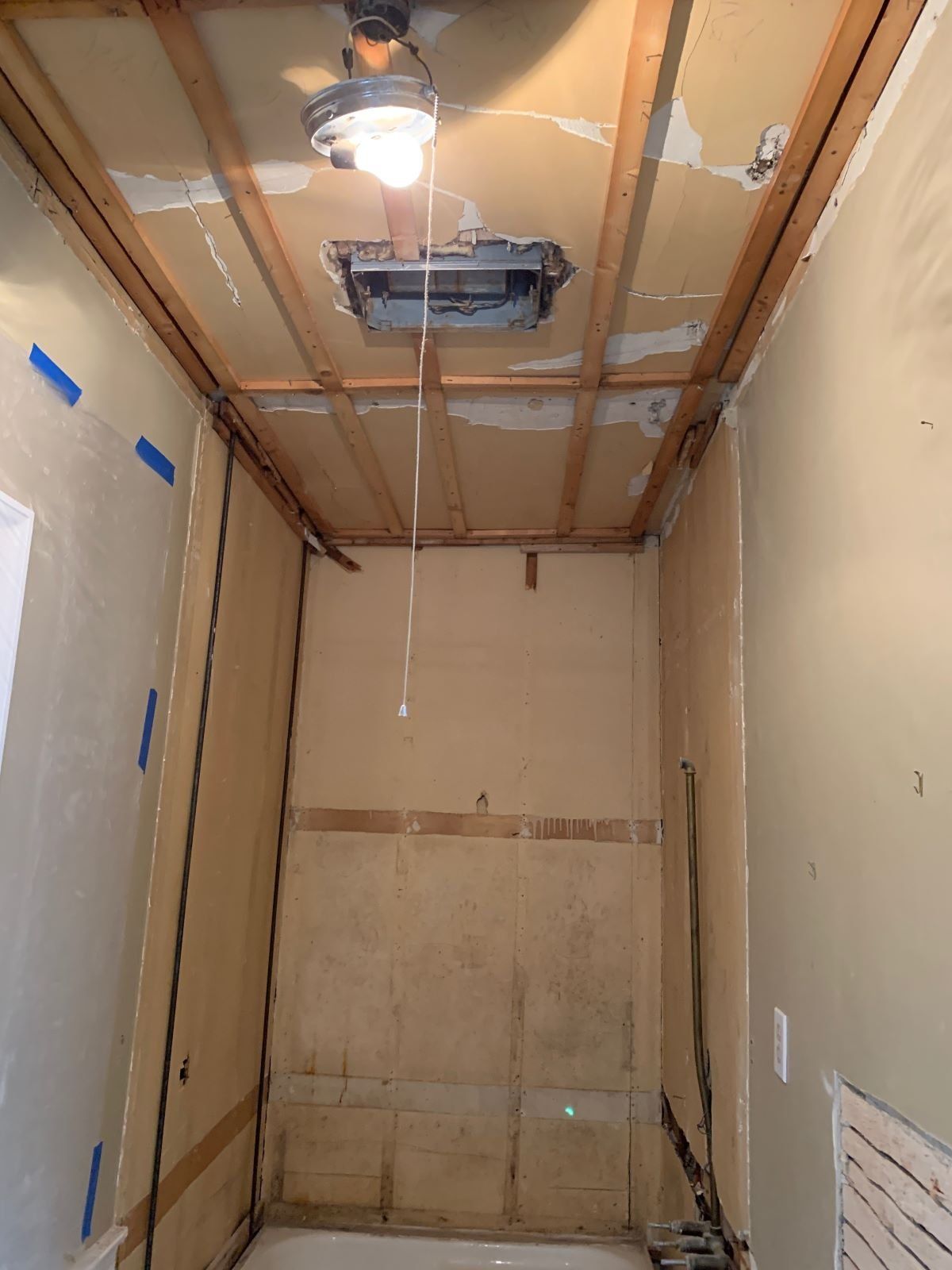 A bathroom with a ceiling fan and a light hanging from it