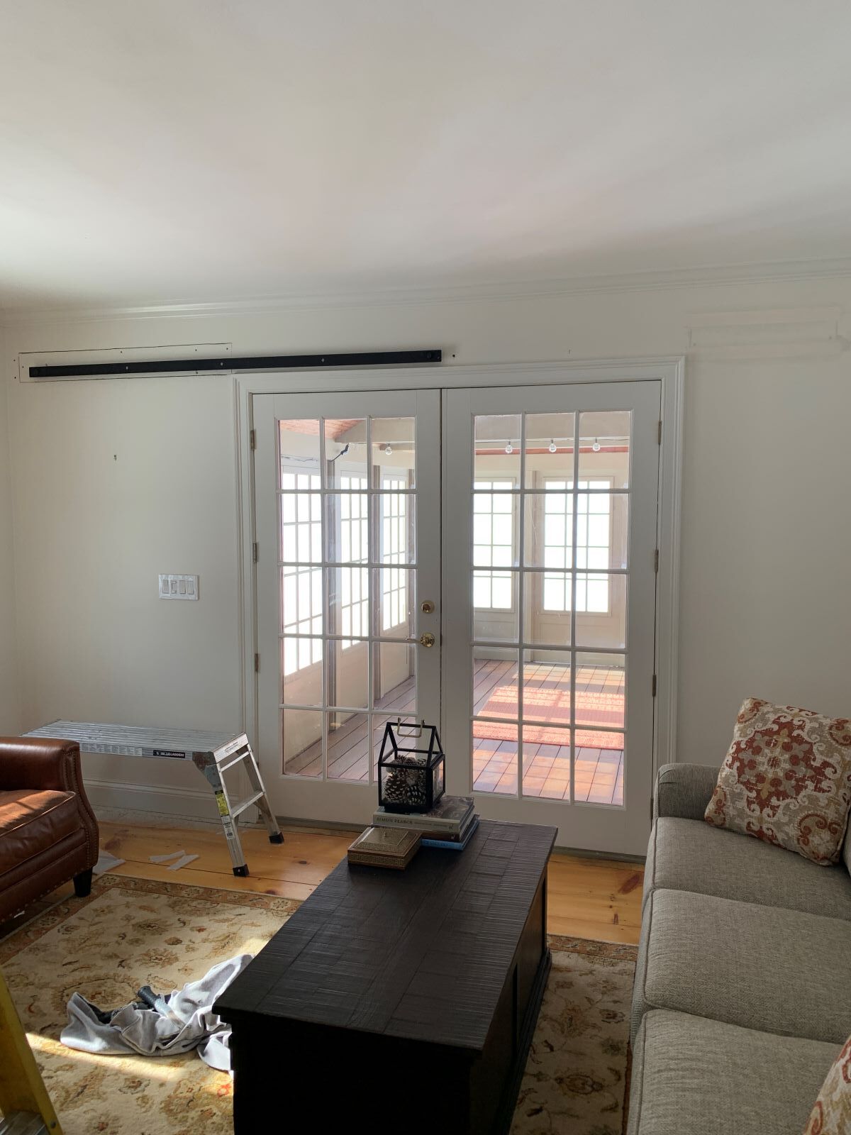 A living room with a couch , coffee table , and sliding glass doors.