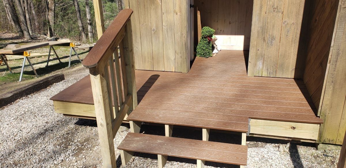 A wooden deck with stairs leading up to a wooden building.